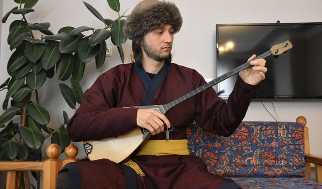 Geleneksel Türk enstrümanlarını çapan giyip çalıyor